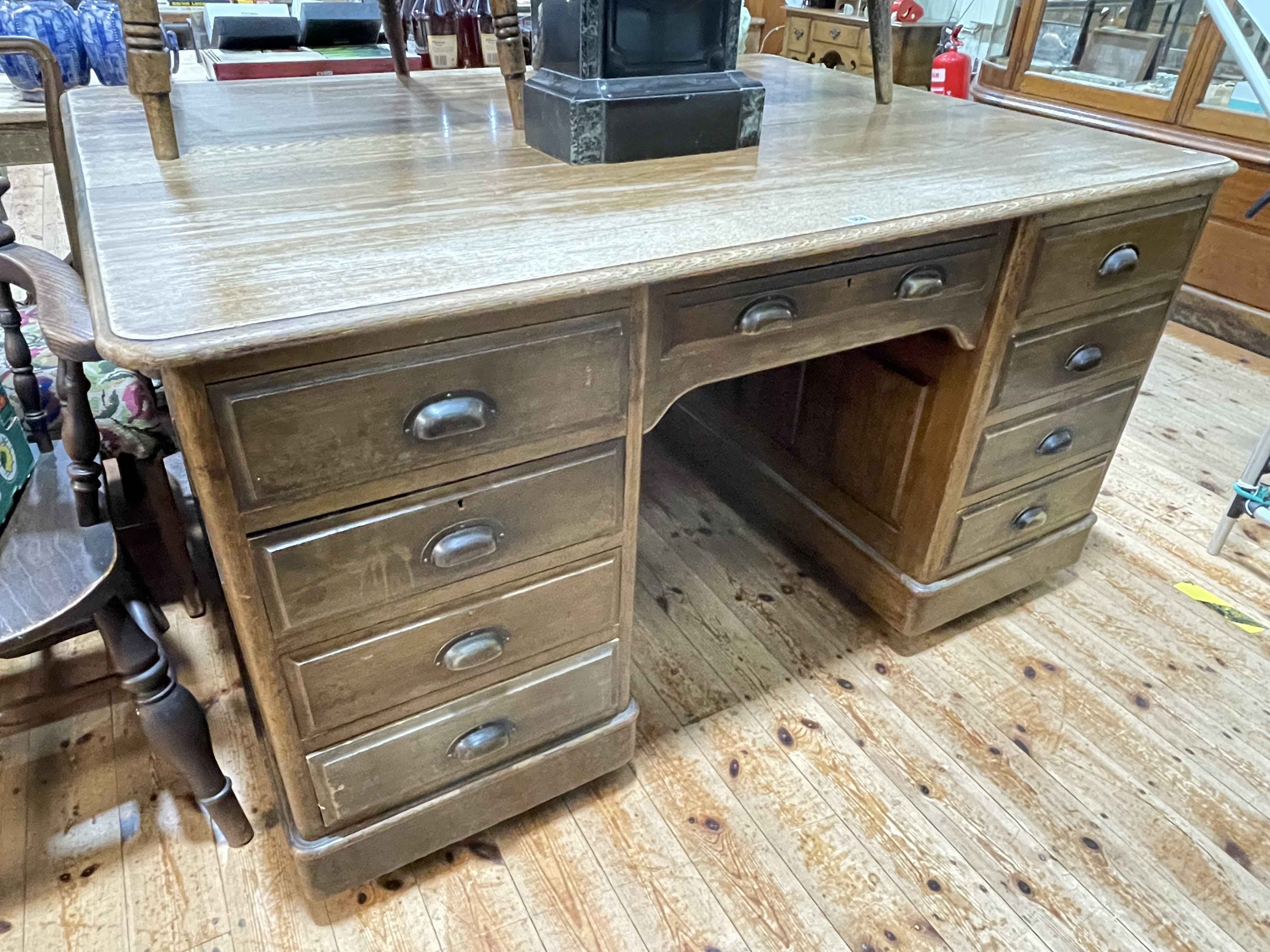 Oak partners desk having nine drawers to front and reverse, 81cm by 153cm by 119cm.