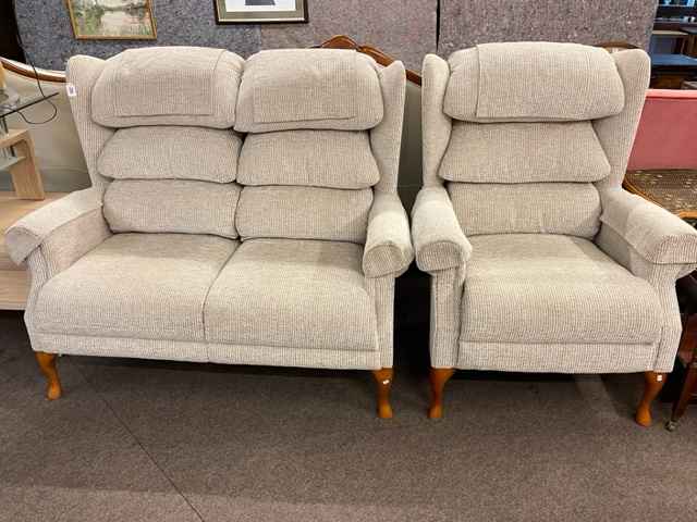 Wing back two seater settee and chair in light fabric.