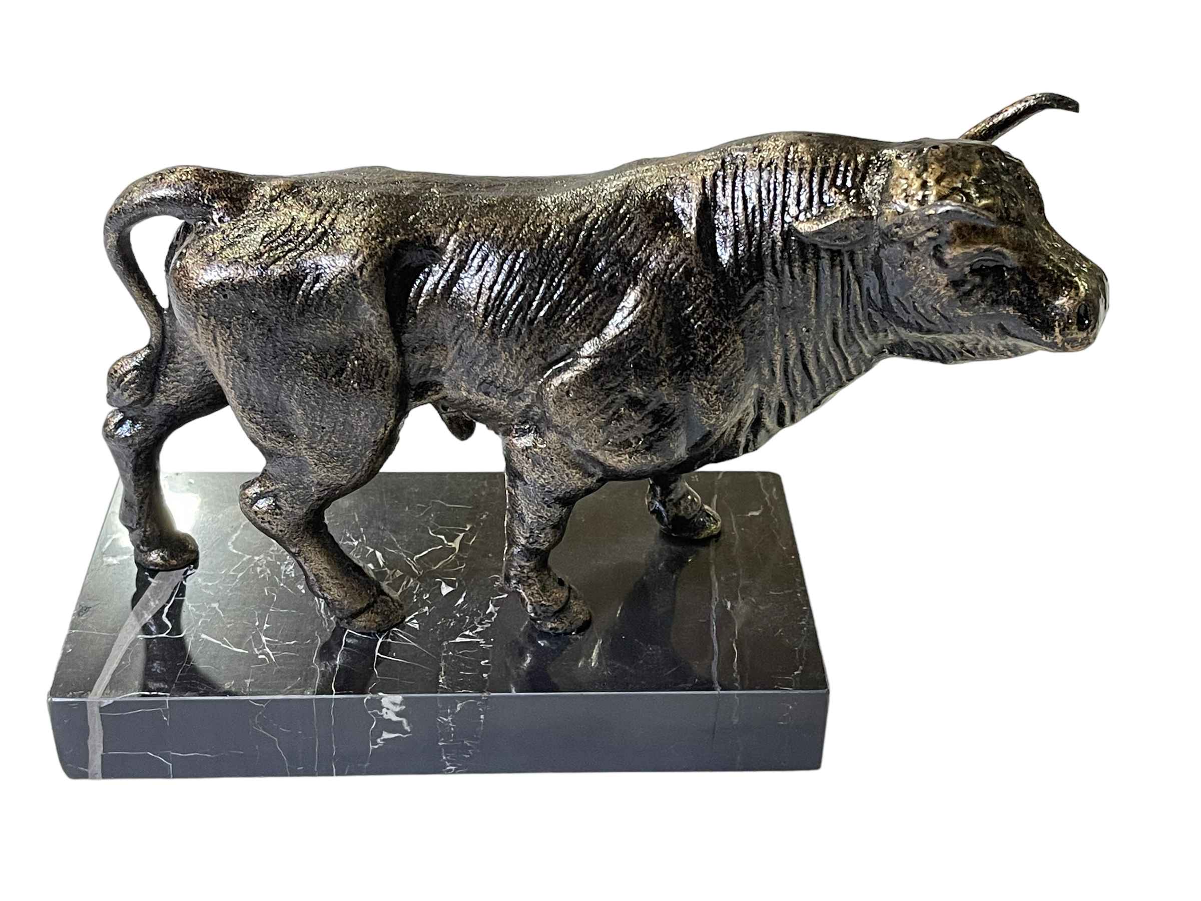Bronze bull on marble base, 29cm long.