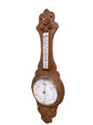 Carved oak barometer-thermometer having enamelled dial.