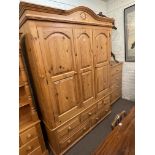 Pine combination wardrobe having two doors above five drawers, 214cm by 157.5cm by 60.