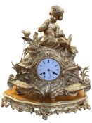 Large ornate gilt metal mantel clock with mounted cherub on giltwood base.