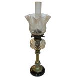 Brass column oil lamp with clear glass reservoir and etched shade.