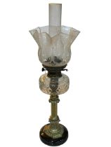 Brass column oil lamp with clear glass reservoir and etched shade.