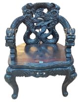 Oriental carved armchair with dragon mask arm terminals.