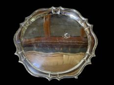 Silver salver on three legs, 26.5cm diameter.