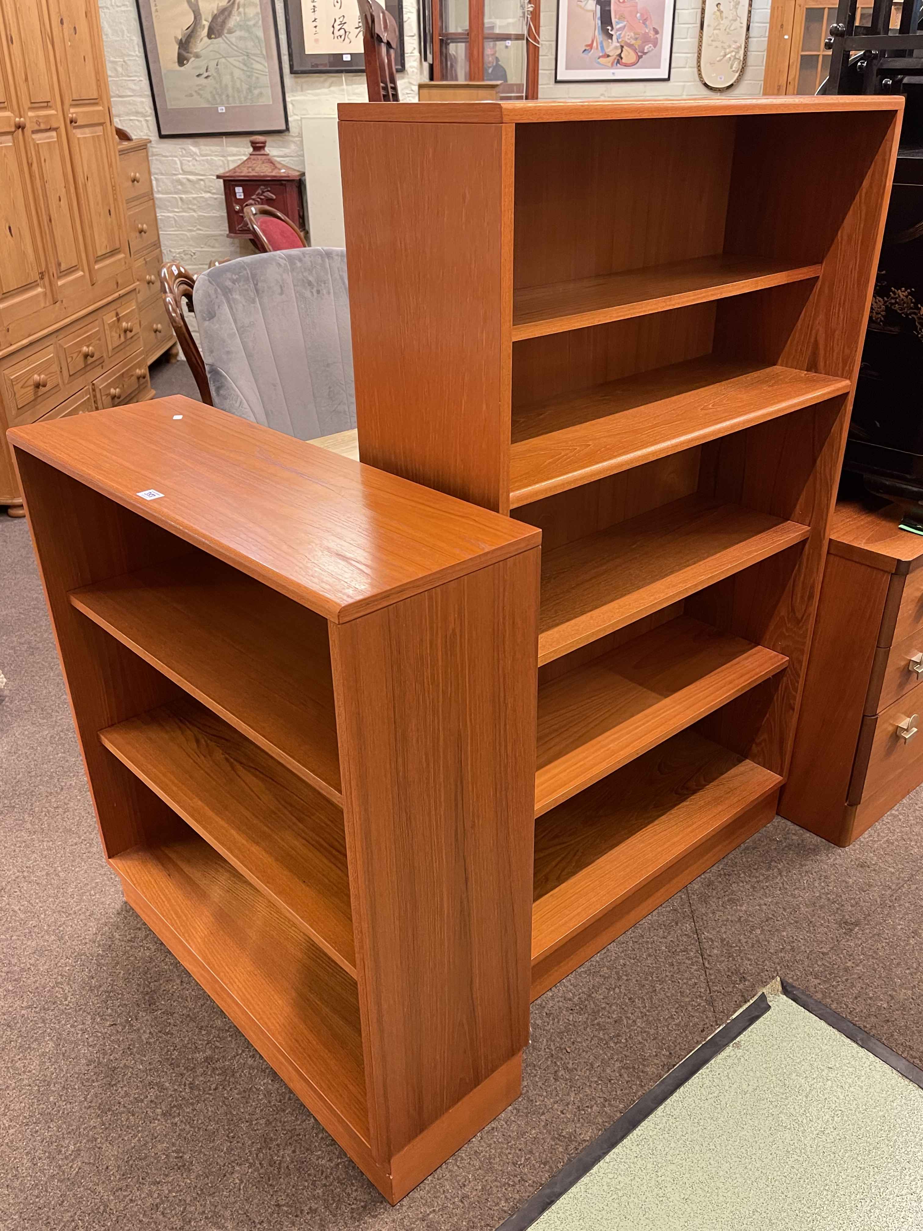 Two teak open bookcases, largest 133cm by 81cm by 28cm.