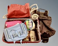 Two shopping trolleys together with a luggage case containing a quantity of assorted bags.