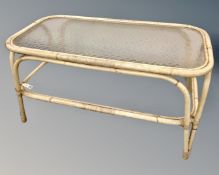 A 20th century bamboo and wicker two tier coffee table with glass shelves.