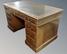 A 19th century oak twin pedestal writing desk fitted with leather inset panel and nine drawers