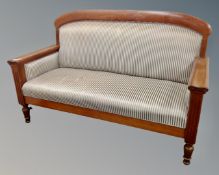 A 19th century mahogany Biedermeier settee upholstered in striped fabric.