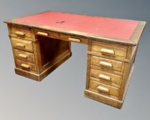 An Edwardian twin pedestal desk fitted with nine drawers (width 152cm)