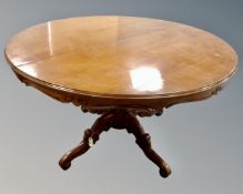 A contemporary Italian style circular pedestal extending dining table in a mahogany finish