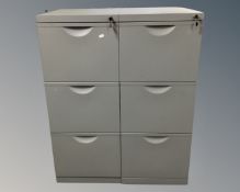 Two metal three drawer filing cabinets with keys.