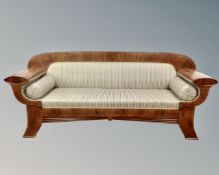 A 19th century inlaid mahogany Biedermeier settee upholstered in striped fabric with two bolster