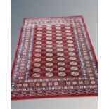 A machine made rug of Tekke design, on red ground,