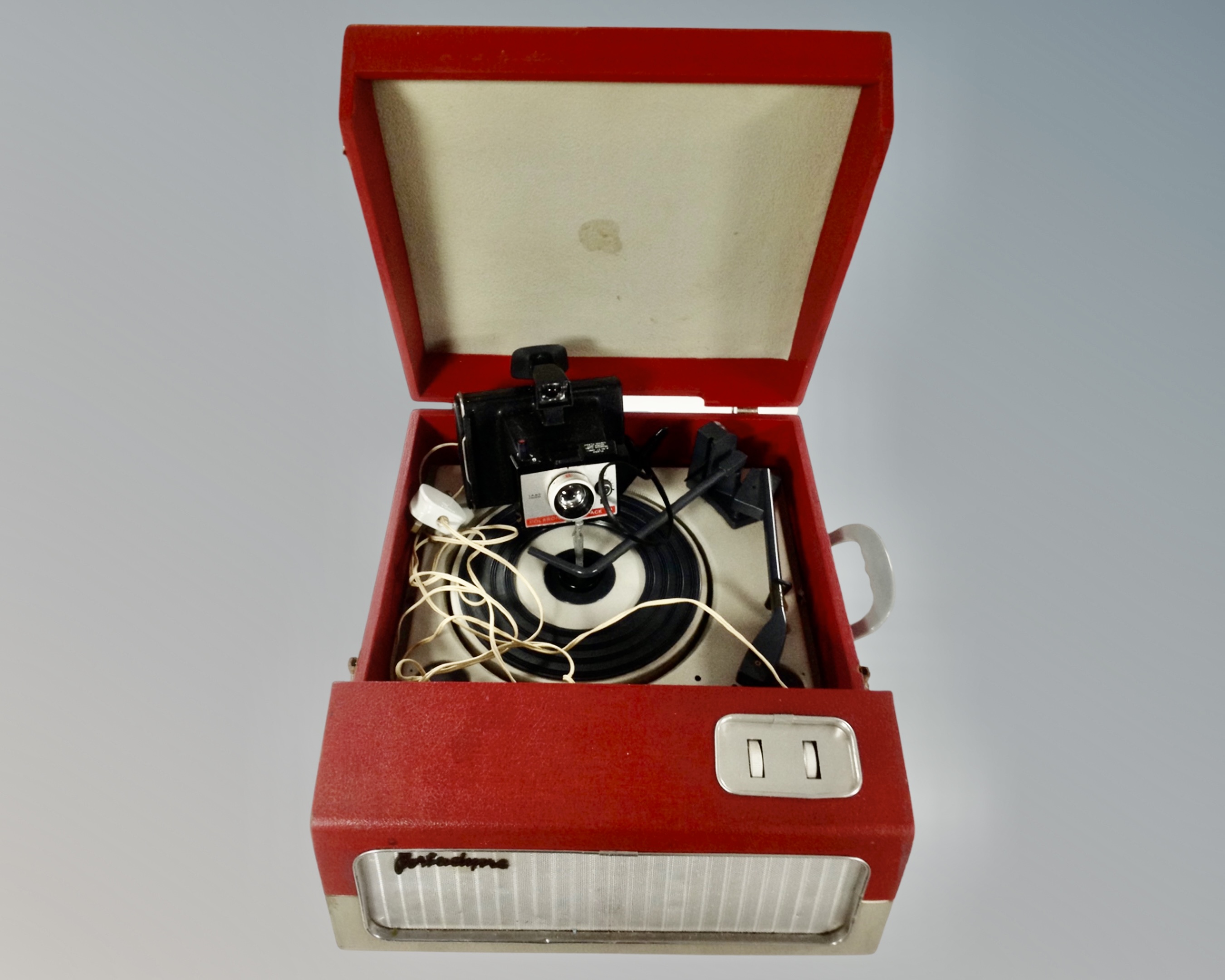 A mid-20th century Portadyno electric tabletop record player together with a vintage Polaroid