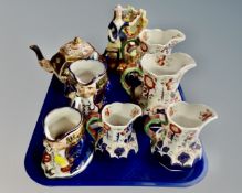 A tray containing a set of four Allertons Imari patterned jugs together with two Allertons lustre