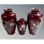 Three 20th century Japanese red cloisonne vases decorated with flowers and blossom,