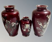Three 20th century Japanese red cloisonne vases decorated with flowers and blossom,