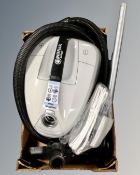 A Nilfisk Select cylinder vacuum with hose and accessories.