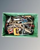 A crate containing a quantity of vintage hand tools including spanners, hand saws, garden tools.