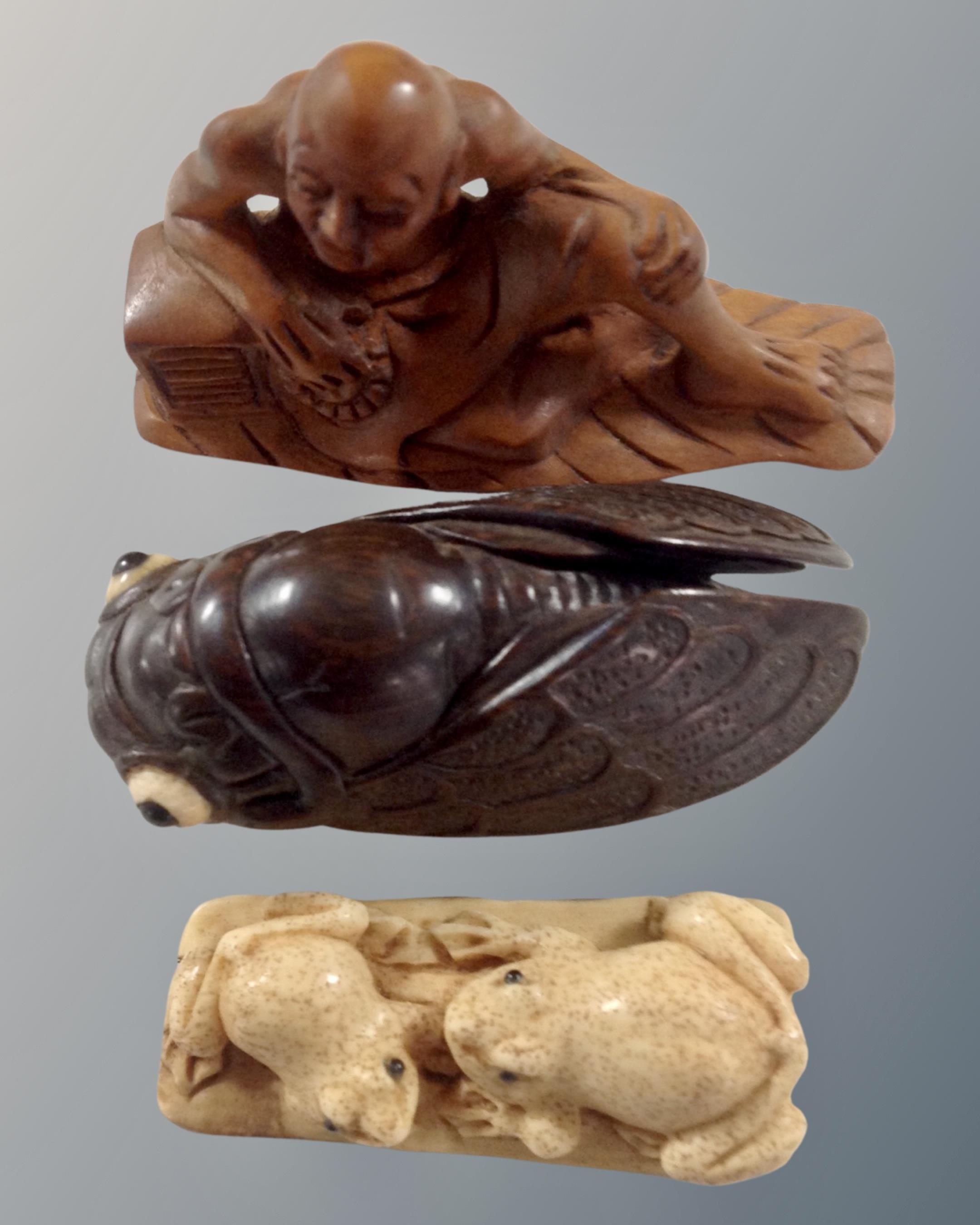 A carved fruit wood netsuke of a gentleman seated,