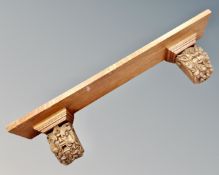 An Edwardian oak wall shelf with grotesque carving supports.