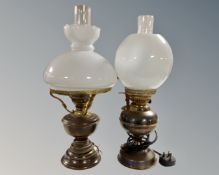 Two brass oil lamps with opaque shades and chimneys, converted to electric.