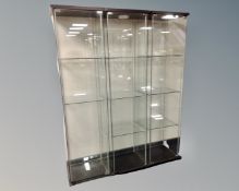 Three IKEA Detolf glass display cabinets.