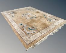 A Chinese carpet with dragon decoration on cream ground, 279cm by 380cm.