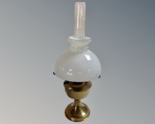 A brass Aladdin oil lamp with opaque glass shade and chimney.