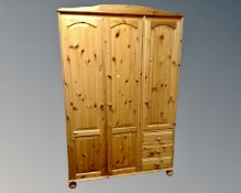 A contemporary pine triple door wardrobe fitted with three drawers (width 122cm)