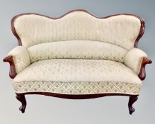 A 19th century mahogany framed settee upholstered in a classical fabric.