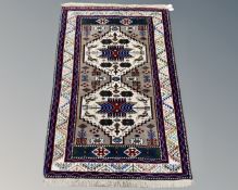 An Afghan/Caucasian rug on cream ground,
