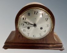 A 20th century oak cased eight day mantel clock with silvered dial
