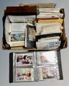 A box containing albums and files of postcards, first day covers, letters with stamps.
