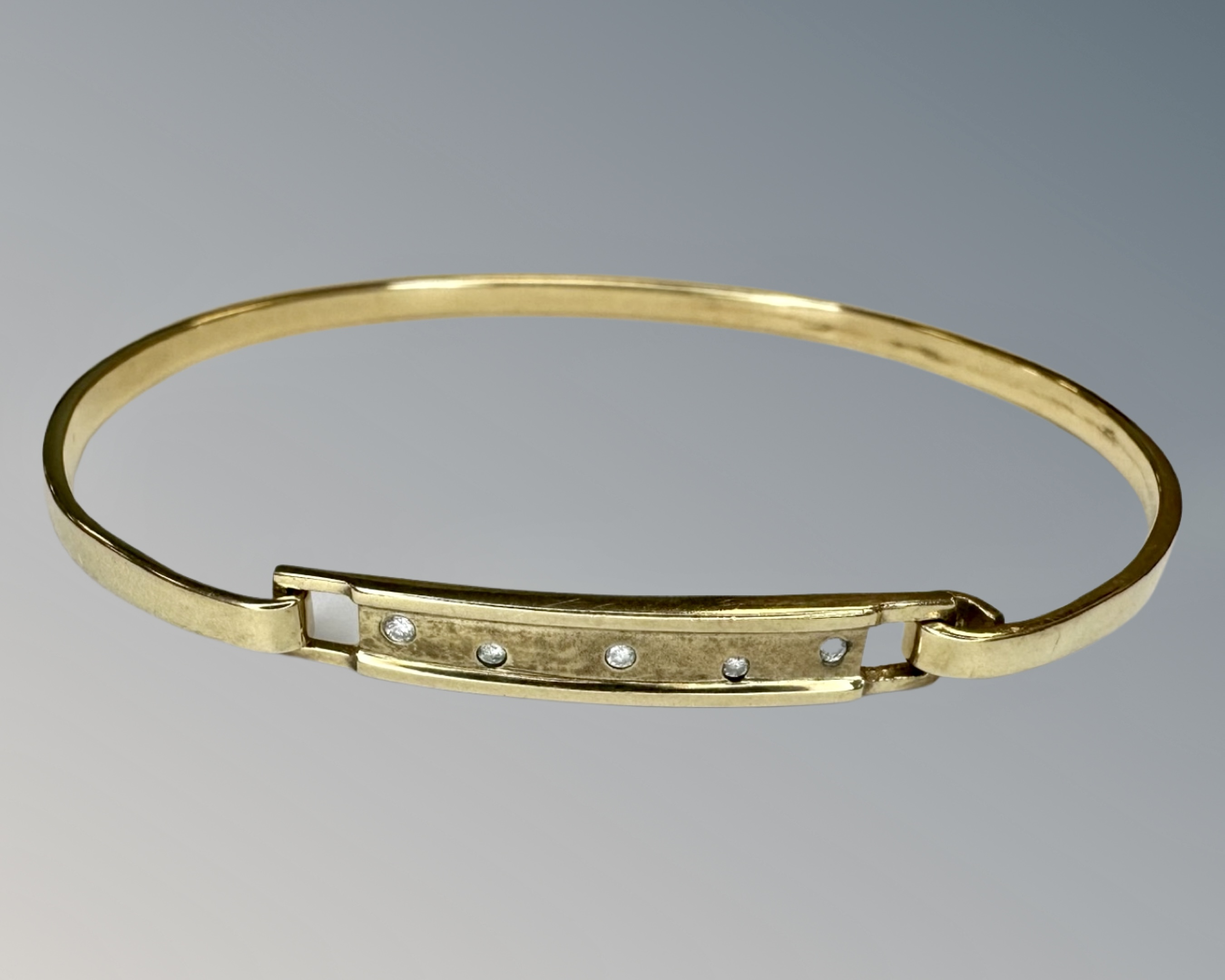 A yellow gold bangle set with diamonds, approx 6cm diameter, 9.6g.