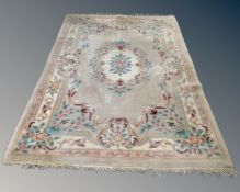 A Chinese floral embossed fringed carpet on beige ground (length 282cm),