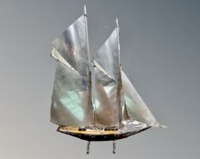 A wood and chrome model of a sailboat.