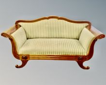 A 19th century mahogany scroll-arm settee upholstered in a striped fabric.