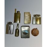 A collection of lighters including one in the form of a French 5 Franc coin.