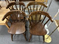 A set of four stained beech elbow chairs.