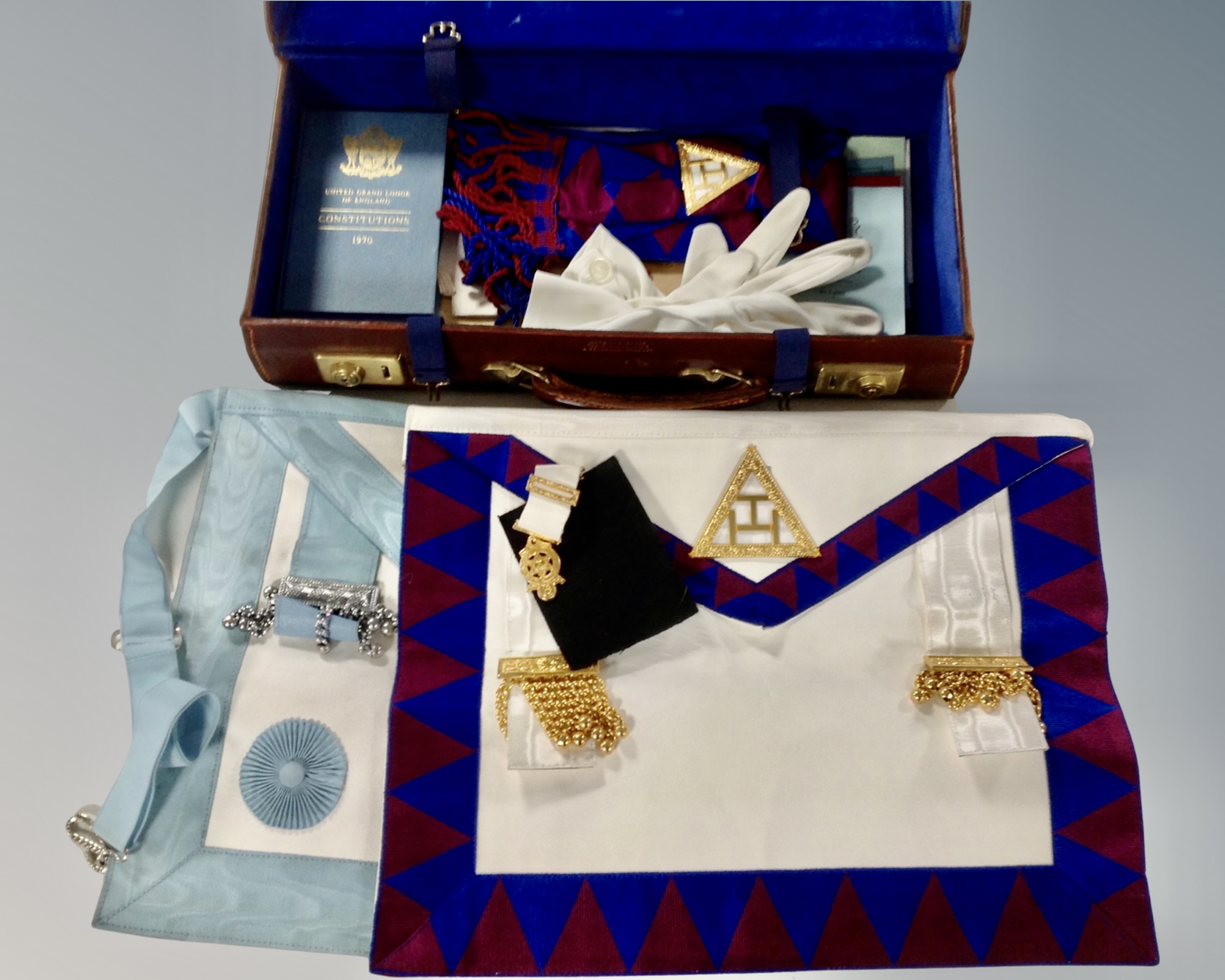 A leather case containing Freemason's ephemera, aprons and medal.