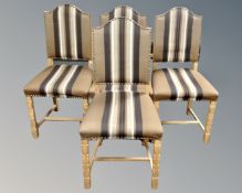 A set of four Danish blond oak dining chairs upholstered in a striped fabric.