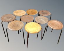 Nine mid-20th century plywood topped stools on metal legs.