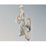 Two Lladro figures, girl with chicken and girl with pig.