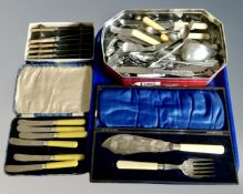 A tray containing a tin containing a quantity of stainless steel and plated cutlery,