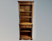 A carved oak double bookcase fitted with central drawer (width 61cm)