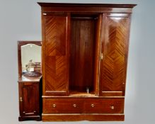 An Edwardian mahogany triple door wardrobe with central mirrored panel door,